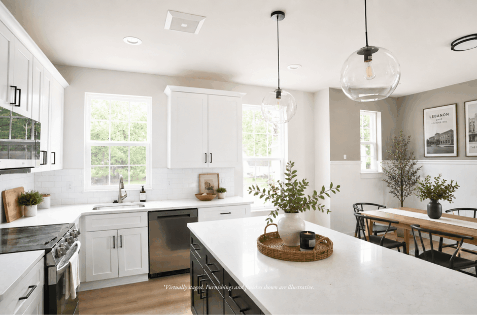 Kitchen in a Lebanon Landing 3 bedroom townhome with white Shaker cabinetry, dark island base, quartz countertops, and framed Lebanon Ohio historical wall art.