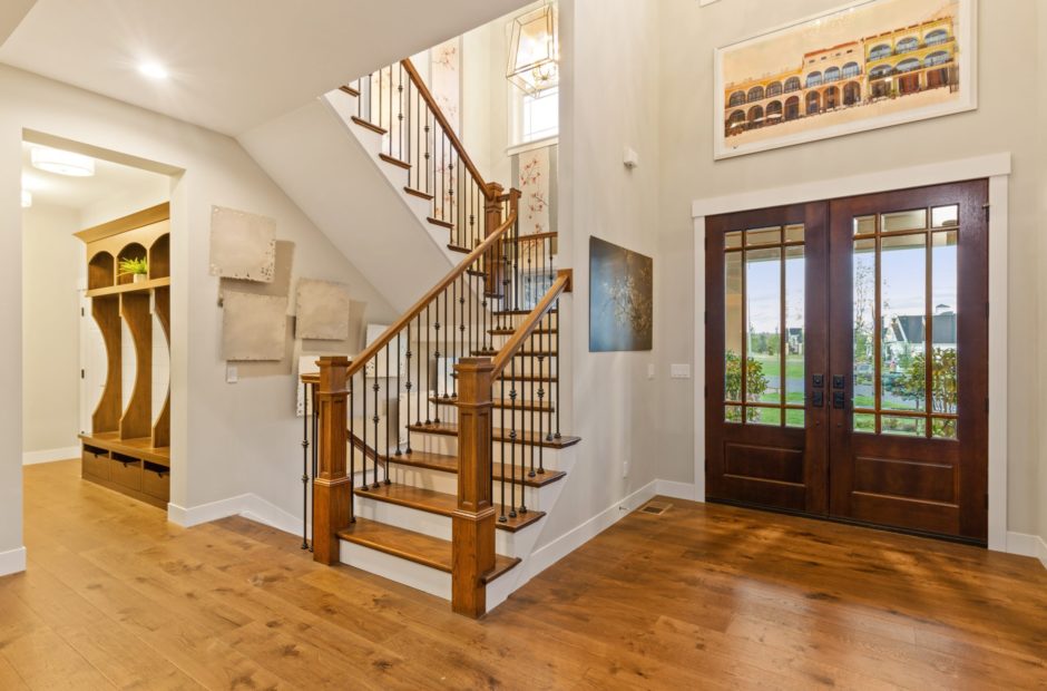 Entryway of the Shaker Run Homearama home featuring a mudroom, elegant staircase, and open vaulted ceiling by Justin Doyle Homes
