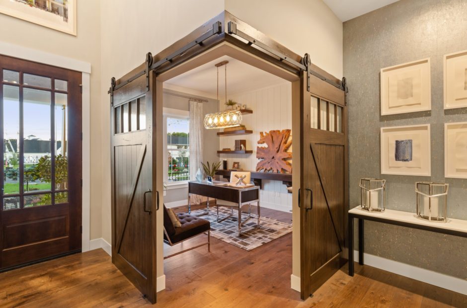 Home office in the Shaker Run Homearama home featuring sliding wooden corner barn doors by Justin Doyle Homes