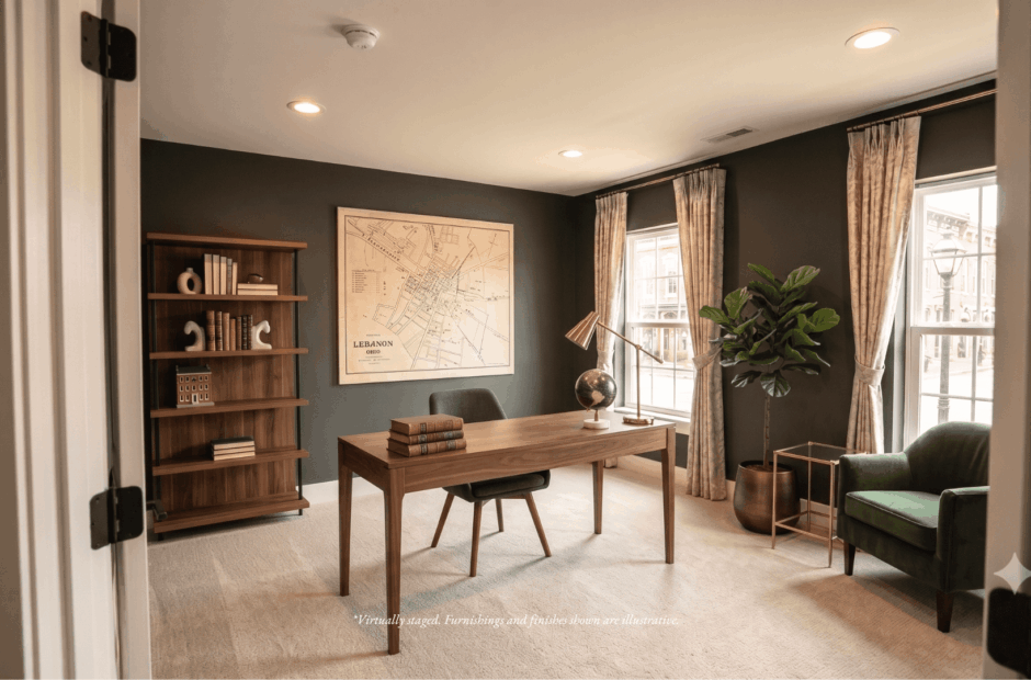 First-floor home office in a Lebanon Landing 3 bedroom townhome with dark charcoal walls, walnut desk, framed historical map of Lebanon Ohio, and windows with abundant natural light.