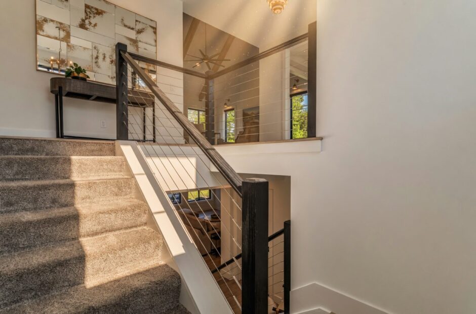 Oakmont II staircase with cable railing, carpeted treads, and open view to vaulted great room by Justin Doyle Homes — custom home builder Cincinnati