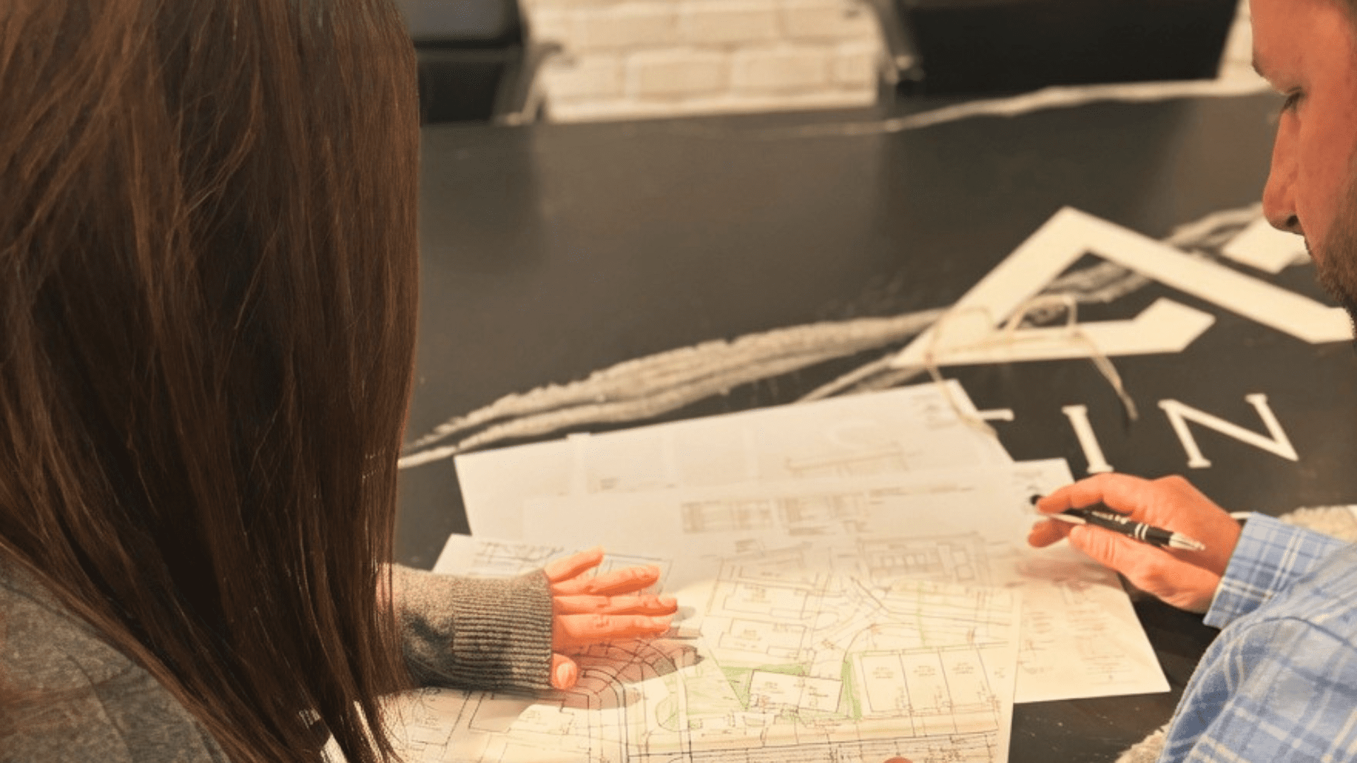 JDH consultant reviewing custom home floor plans with client at Justin Doyle Homes design consultation, Mason Ohio