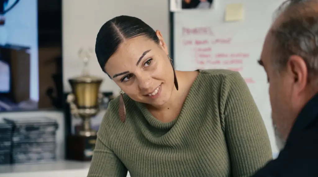Designer smiling across the desk at a client during a home design consultation