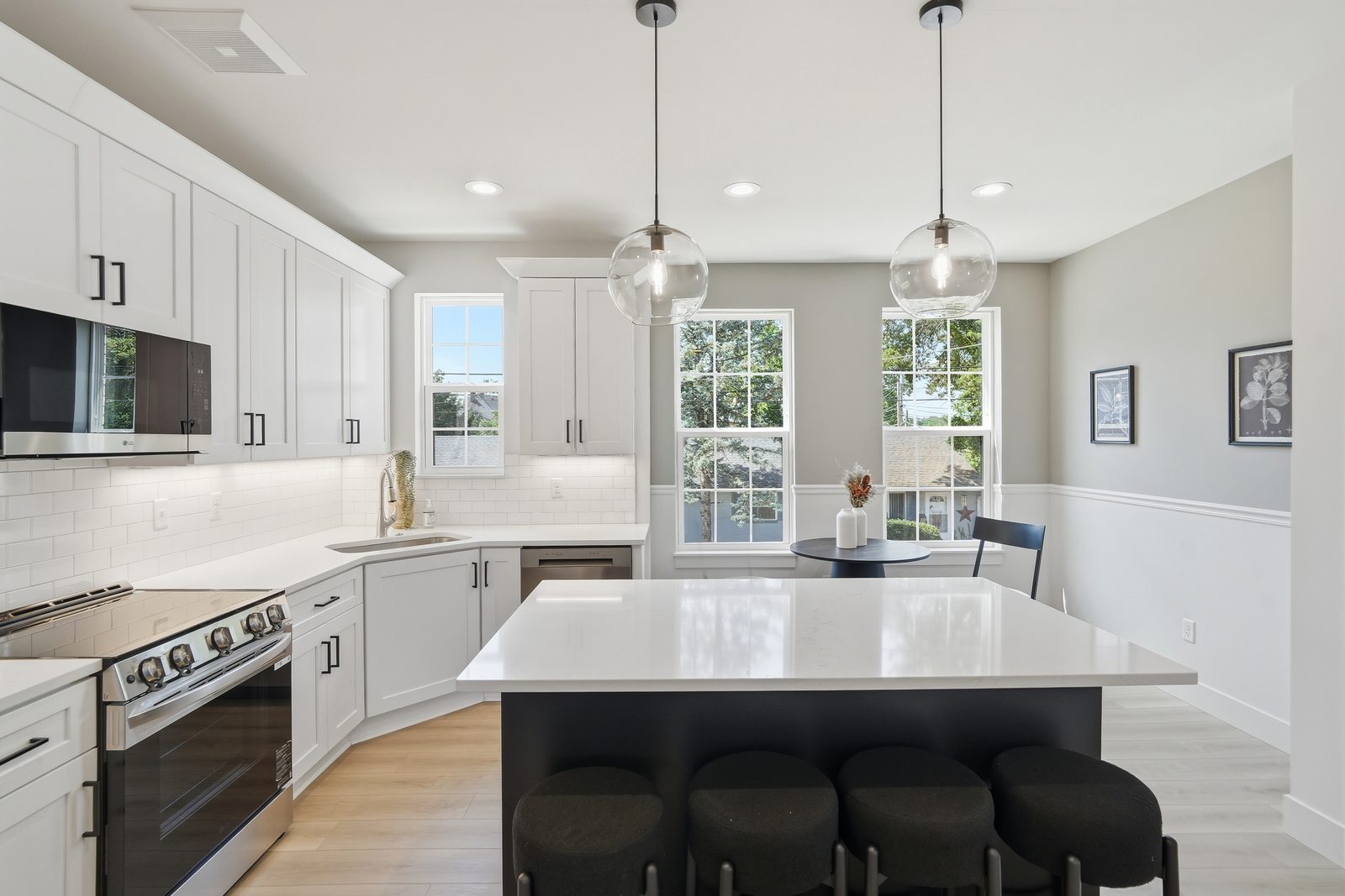 Kitchen in a Lebanon Landing 2 bedroom townhome with white cabinets, quartz countertops, globe pendants, and a large center island